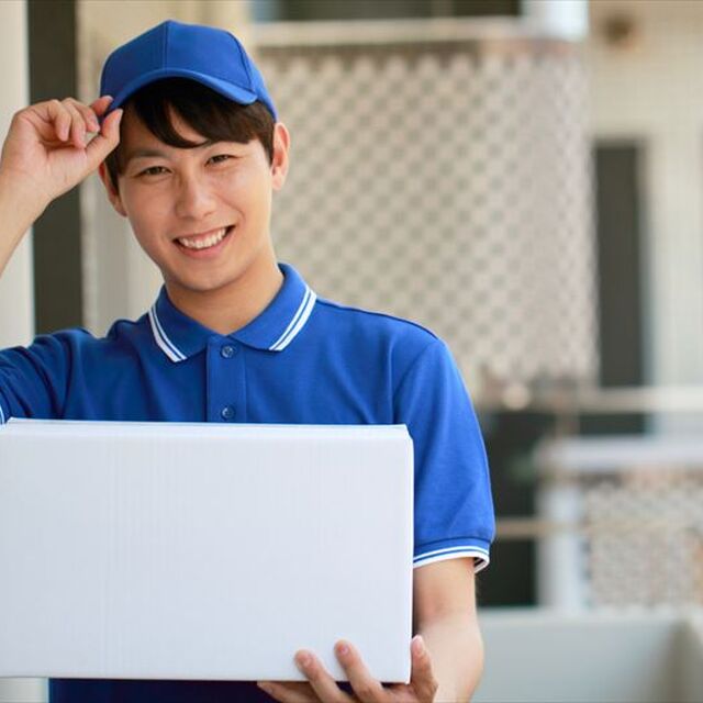 マンションで荷物を配達する男性スタッフ